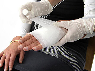 Ersthelfer legt Verband an